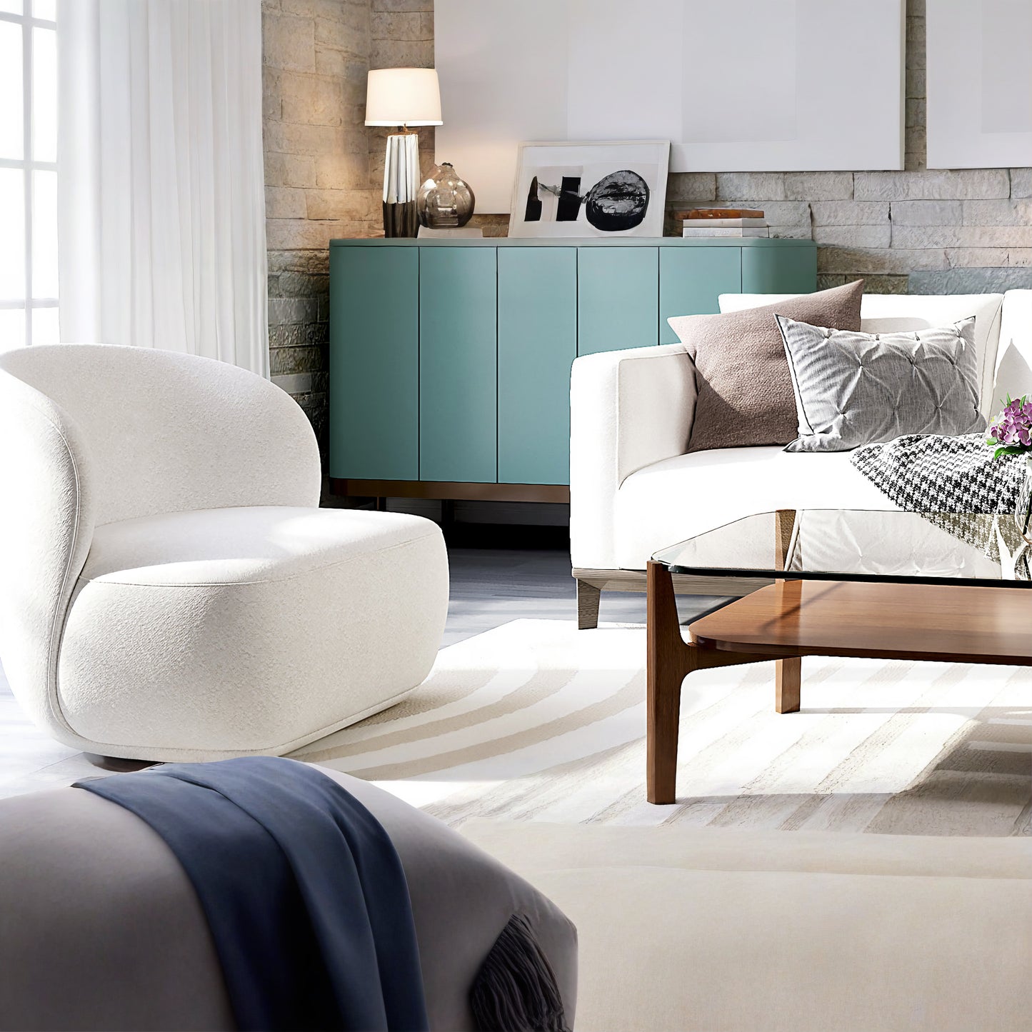Modern living room with white sofa, armchair, and teal cabinet.