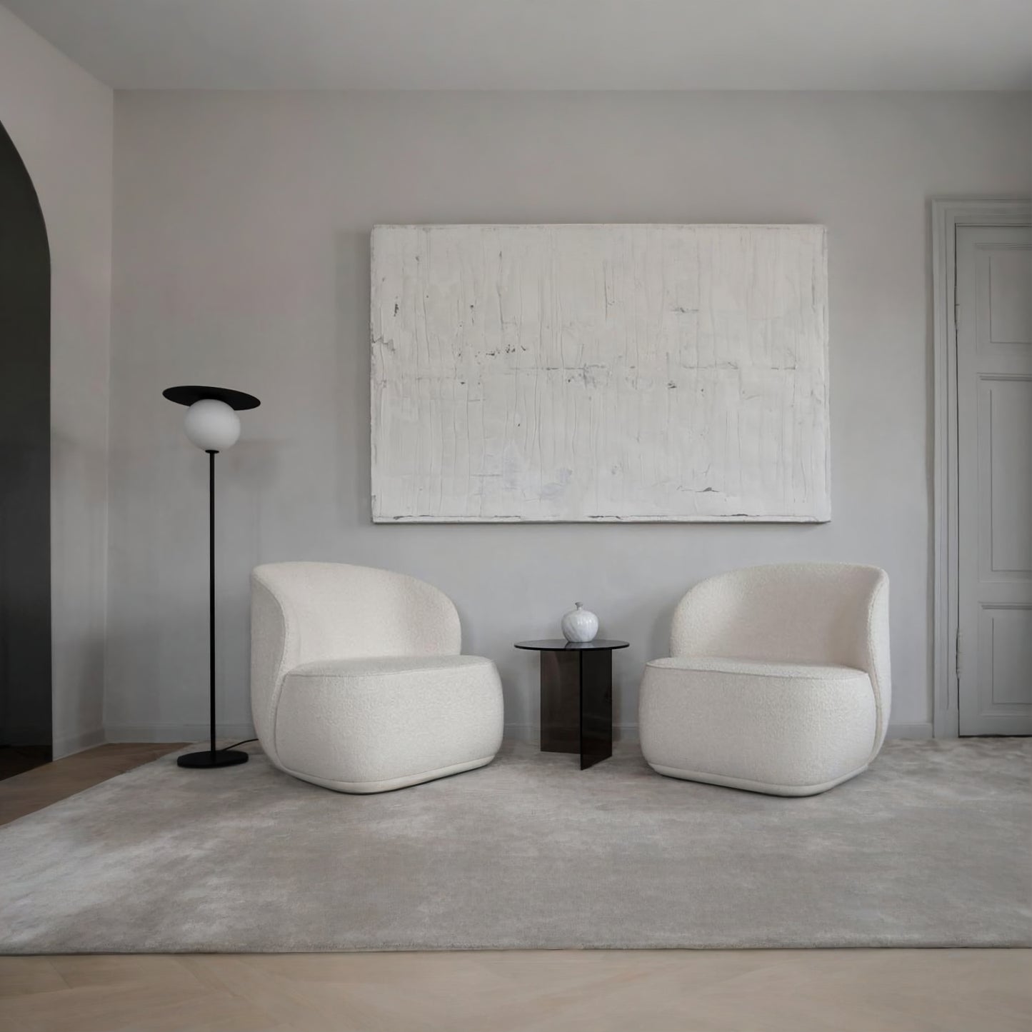 Modern living room with two white chairs, a side table, and a abstract painting on a gray wall.