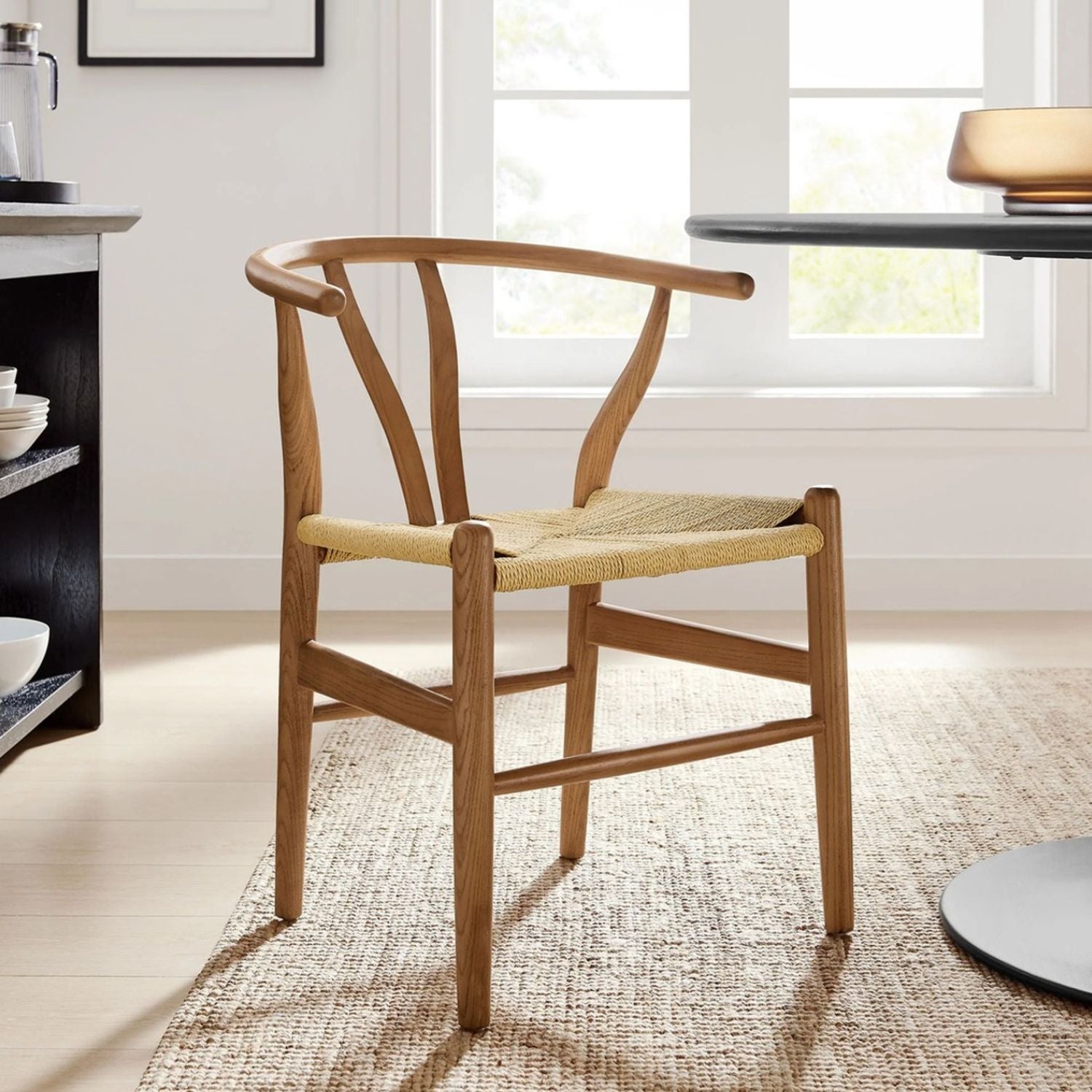 Scandinavian-style wishbone chair in walnut finish in a living room with a rug underneath