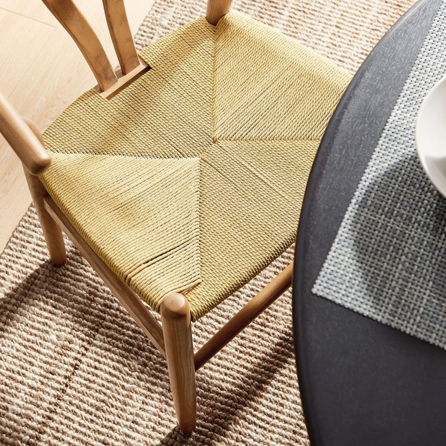 Wishbone Dining Chair at the end of reclaimed wood table, rug underneath in dining layout